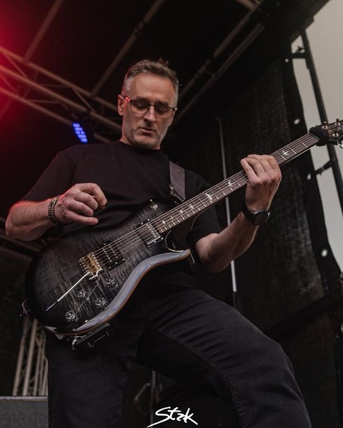 Rafał — gitarzysta zespołu Biała Wilczyca podczas koncertu plenerowego